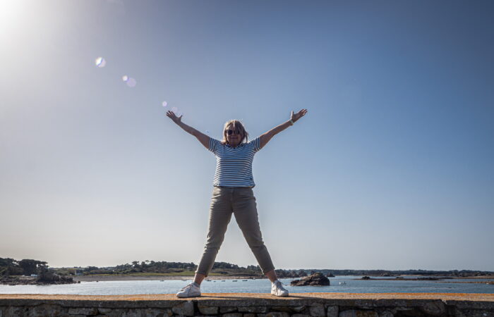 Yogaglück am Meer Frau auf einer Mauer mit Glück