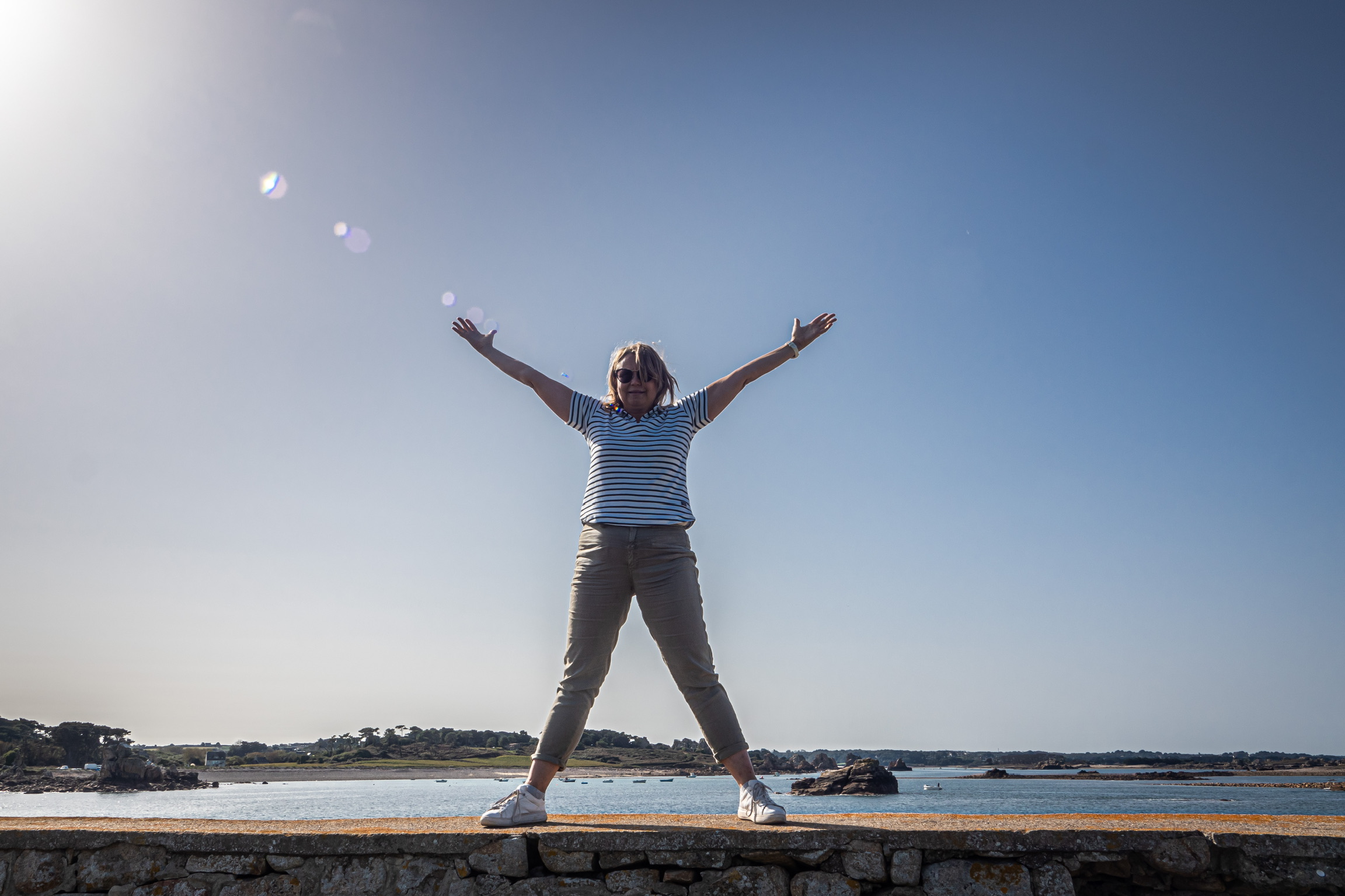 Yogaglück am Meer Frau auf einer Mauer mit Glück