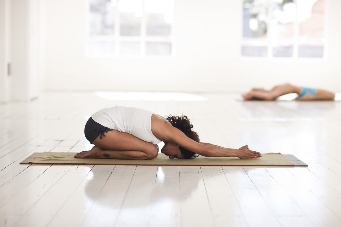 Frau auf dem Boden gekniet beim yoga